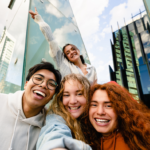 Image of young people taking selfie in front of buildings