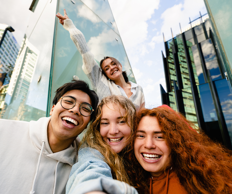 Image of young people taking selfie in front of buildings